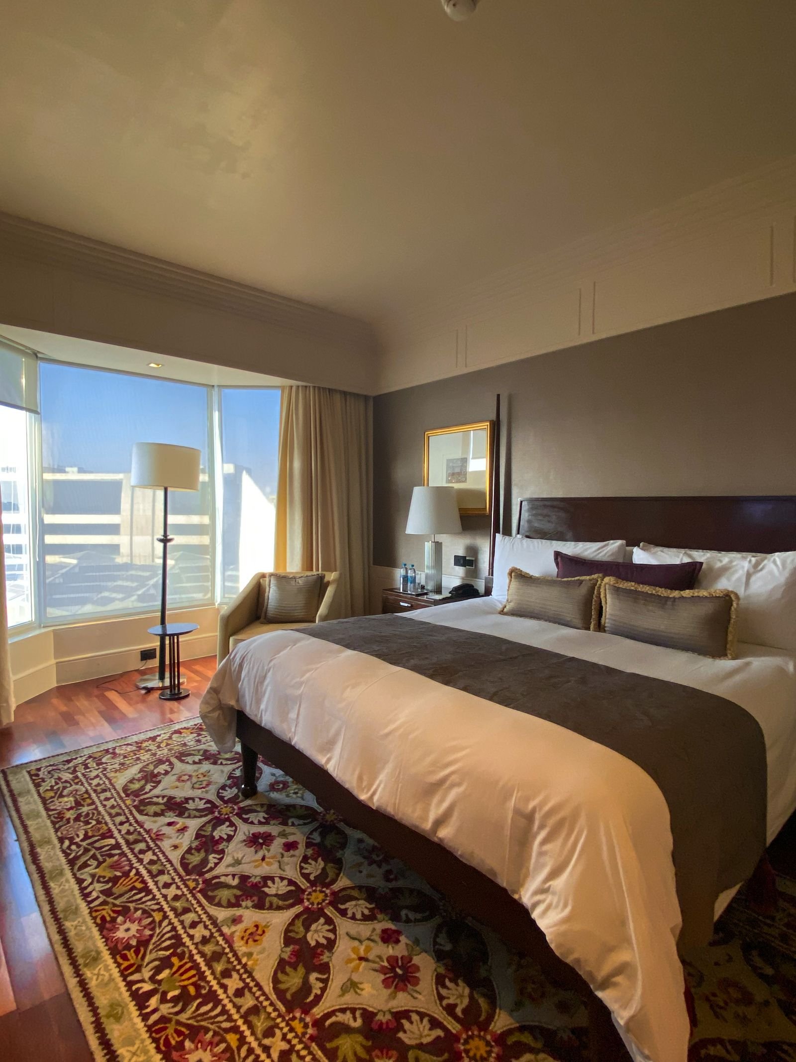 Furnished hotel room with a made bed